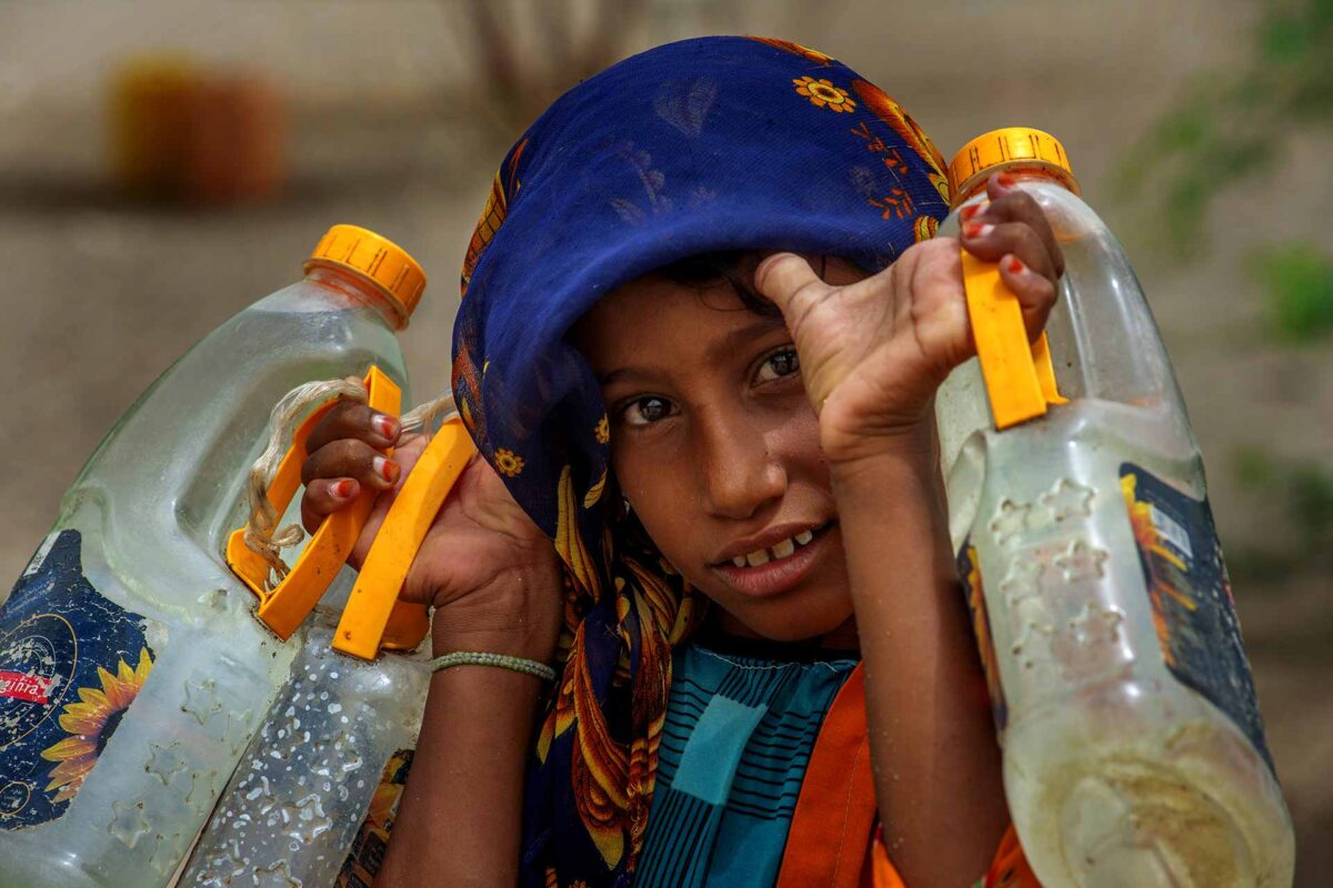 A young Yemeni fetches water at a makeshift camp