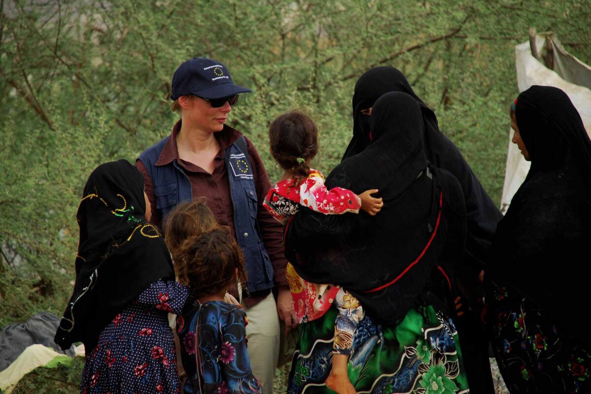 An EU official, centre left, listens to Yemeni refugees