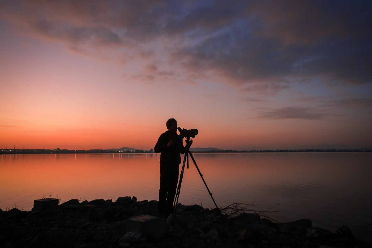 An ornithologist watching birds at Lake Burgas before sunrise